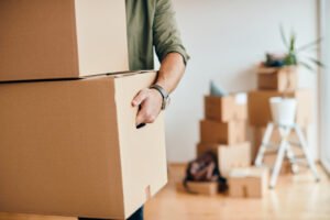 Déménageur professionnel Demova portant des cartons de déménagement à Paris.