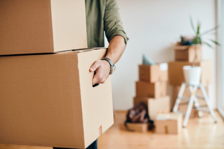 Déménageur professionnel Demova portant des cartons de déménagement à Paris.